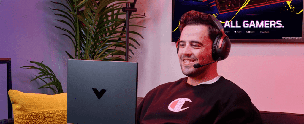 Man using HP Victus laptop with Hyperx headphones