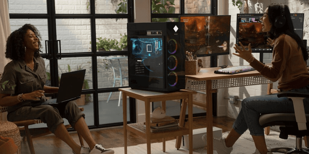 Two young women talking in an office with an HP OMEN 45L